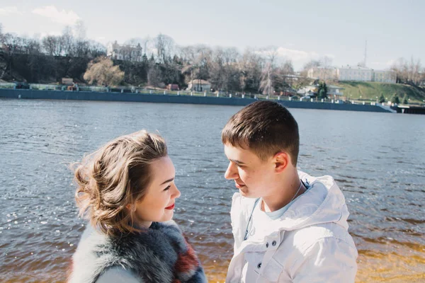 Happy couple in love hugging and sharing emotions, holding hands on the river bank — Stock Photo, Image