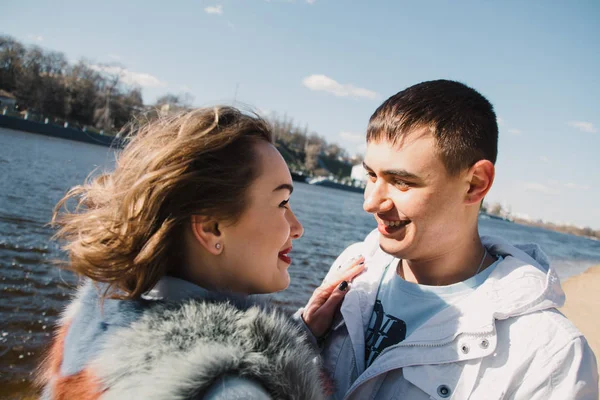 Pareja feliz enamorada abrazando y compartiendo emociones, tomados de la mano en la orilla del río — Foto de Stock