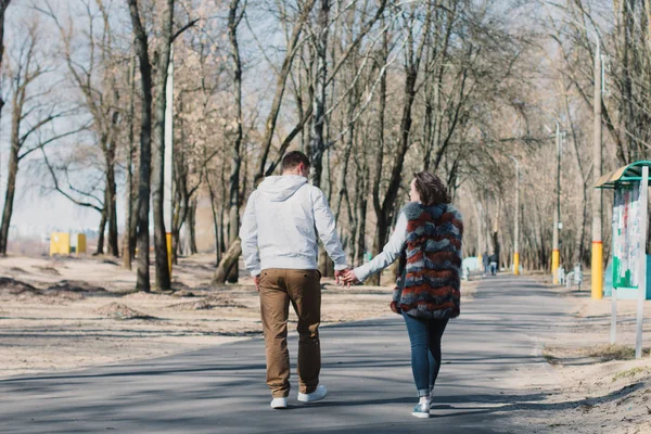 Pareja feliz enamorada abrazando y compartiendo emociones, tomados de la mano caminando por el parque — Foto de Stock