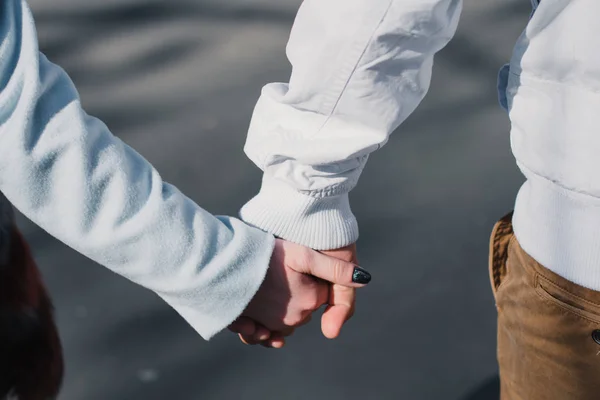 Glückliches verliebtes Paar, das sich umarmt und Emotionen teilt, Händchen haltend im Park spazieren geht — Stockfoto