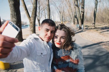 Mutlu çifte sarılma ve duygular, parkta yürüyüş ve selfies yapma el ele tutuşarak paylaşımı seviyorum