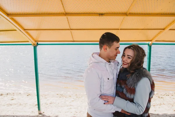 Happy couple in love hugging and sharing emotions, holding hands on the river bank — Stock Photo, Image