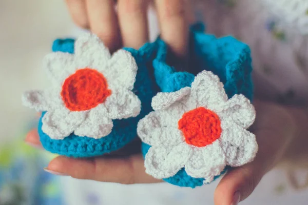 Baby knitted slippers in hands