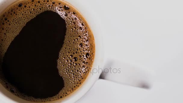 Cup of coffee on a white background with rotation, top view — Stock Video