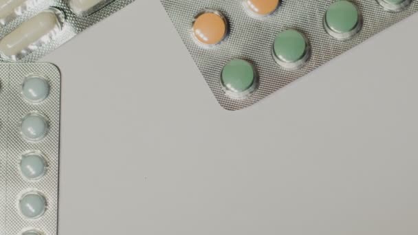 Медичні таблетки розміщені на обертовому столі, зняті з білим безшовним тлом — стокове відео