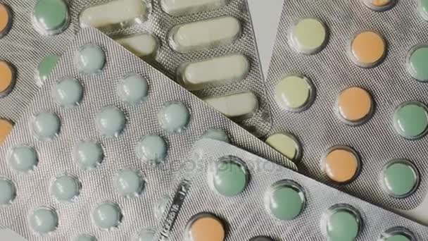 Pilules médicales placées sur la table tournante, prises avec fond blanc sans couture — Video