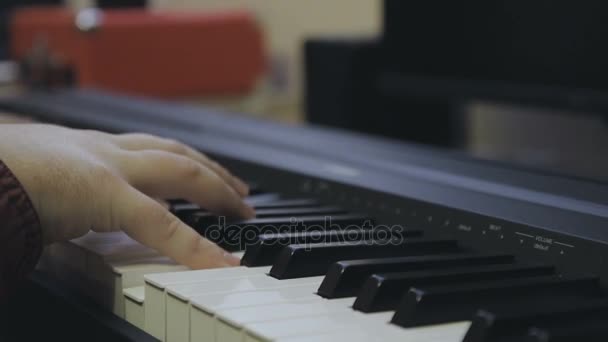 Guy spelar på ett elektroniska piano, händer närbild — Stockvideo