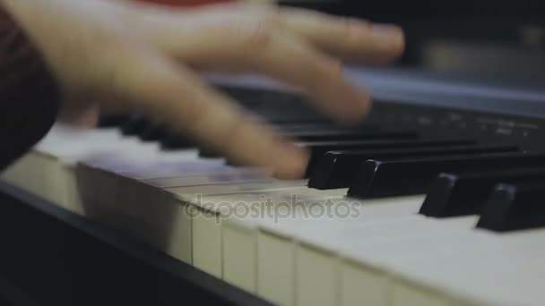 Tipo tocando en un piano electrónico, manos de cerca — Vídeo de stock