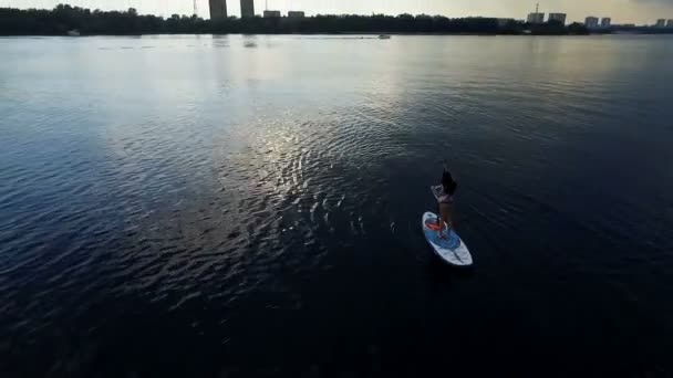 Schieten bird's eye. Vliegende drone langzaam vliegen over het blauwe water. Mooi hotel aan de oever van de rivier — Stockvideo