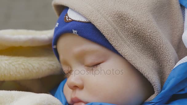 Bebek arabasında uyuyan tatlı küçük oğlan. — Stok video