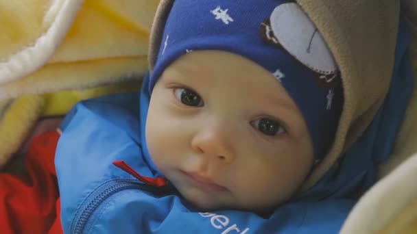 Un bambino piccolo guarda su una sedia a rotelle — Video Stock