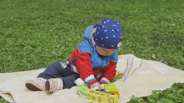 A criança está brincando na grama verde — Vídeo de Stock