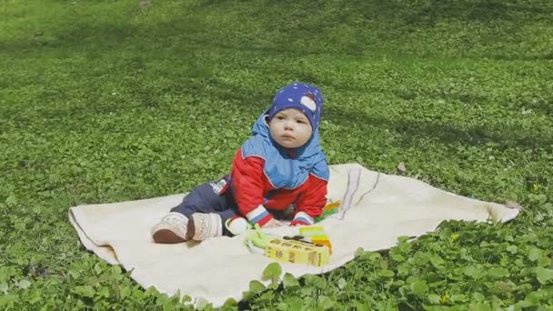 Ребенок играет на зеленой траве — стоковое видео