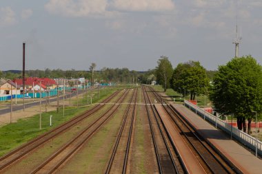Demiryolu gün batımında hareket halinde. Renkli mavi gökyüzüne karşı hareket bulanıklığı olan tren istasyonu, endüstriyel konsept arka plan. Demiryolu seyahati, demiryolu turizmi. Bulanık demiryolu. Ulaşım