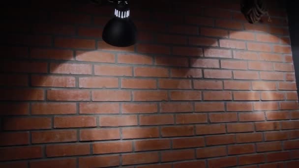 Лампа розжарювання світить на цегляній стіні, текстура цегли . — стокове відео