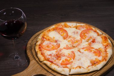 Sıcak parça rustik ahşap bir masa üzerinde erimiş peynirli pizza