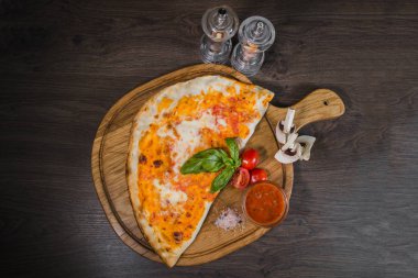 Sıcak parça rustik ahşap bir masa üzerinde erimiş peynirli pizza