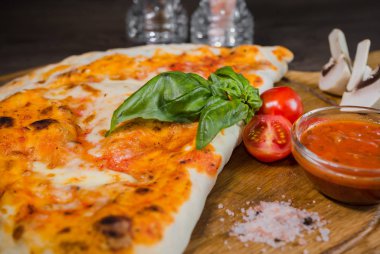 Sıcak parça rustik ahşap bir masa üzerinde erimiş peynirli pizza