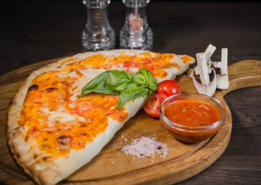 Sıcak parça rustik ahşap bir masa üzerinde erimiş peynirli pizza