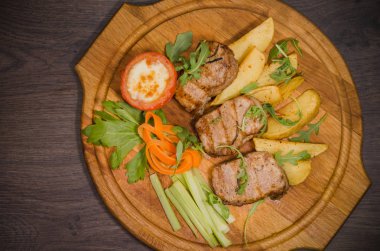 Üç domuz biftek ile kızarmış patates ve sebze ahşap arka plan üzerinde