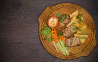 Üç domuz biftek ile kızarmış patates ve sebze ahşap arka plan üzerinde