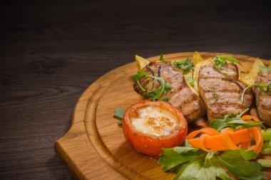 Üç domuz biftek ile kızarmış patates ve sebze ahşap arka plan üzerinde