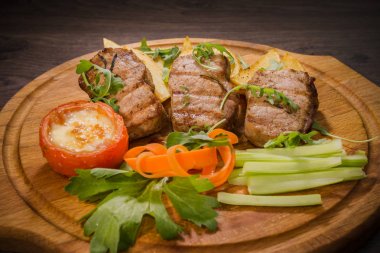 Üç domuz biftek ile kızarmış patates ve sebze ahşap arka plan üzerinde