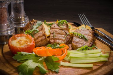 Üç domuz biftek ile kızarmış patates ve sebze ahşap arka plan üzerinde