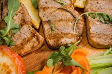 Üç domuz biftek ile kızarmış patates ve sebze ahşap arka plan üzerinde