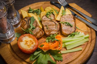 Üç domuz biftek ile kızarmış patates ve sebze ahşap arka plan üzerinde