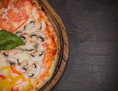 Sıcak parça rustik ahşap bir masa üzerinde erimiş peynirli pizza