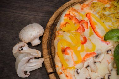 Sıcak parça rustik ahşap bir masa üzerinde erimiş peynirli pizza