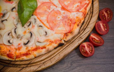 Sıcak parça rustik ahşap bir masa üzerinde erimiş peynirli pizza