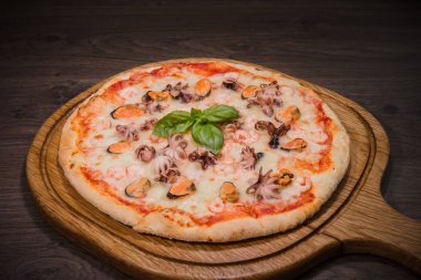 Sıcak parça rustik ahşap bir masa üzerinde erimiş peynirli pizza