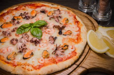 Sıcak parça rustik ahşap bir masa üzerinde erimiş peynirli pizza