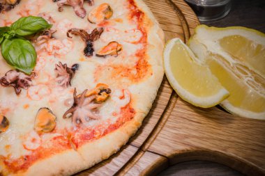Sıcak parça rustik ahşap bir masa üzerinde erimiş peynirli pizza