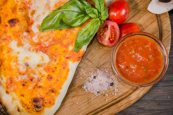 Pedaço quente de pizza com queijo derretido em uma mesa de madeira rústica — Fotografia de Stock