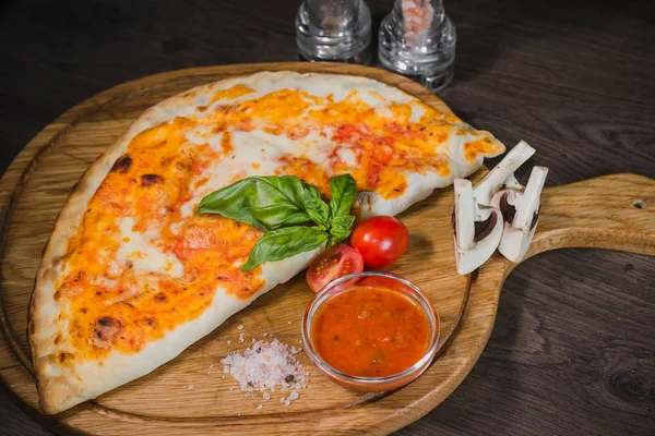 Sıcak parça rustik ahşap bir masa üzerinde erimiş peynirli pizza