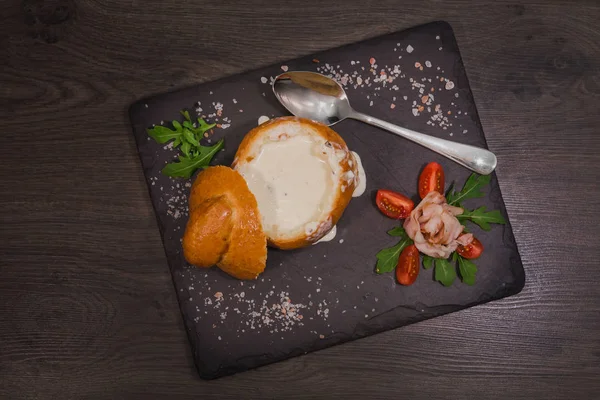 Tuz ve yetkin ile ahşap bir gemide bir ekmek kase taze bezelye çorbası