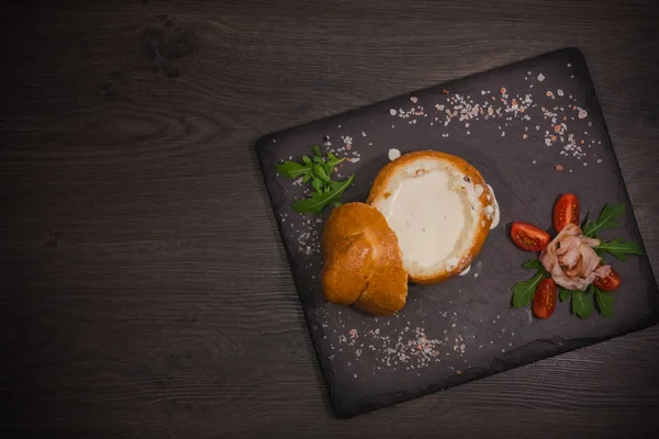 Tuz ve yetkin ile ahşap bir gemide bir ekmek kase taze bezelye çorbası