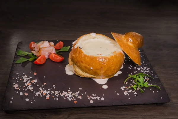 Tuz ve yetkin ile ahşap bir gemide bir ekmek kase taze bezelye çorbası