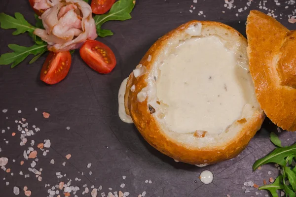 Tuz ve yetkin ile ahşap bir gemide bir ekmek kase taze bezelye çorbası