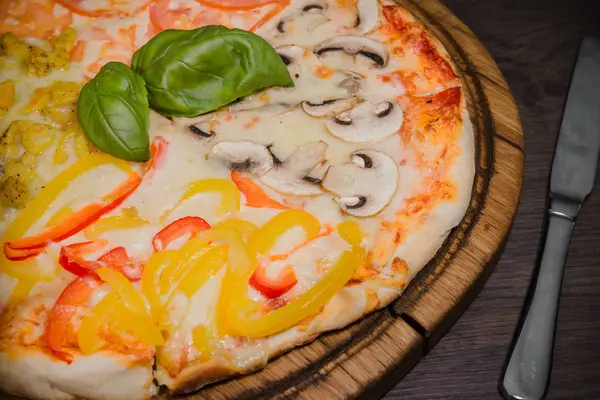 Sıcak parça rustik ahşap bir masa üzerinde erimiş peynirli pizza