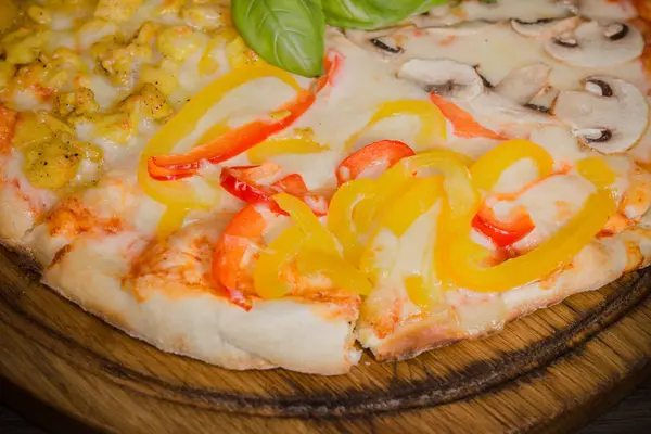 Pedaço quente de pizza com queijo derretido em uma mesa de madeira rústica — Fotografia de Stock