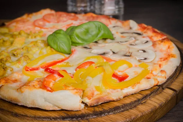 Sıcak parça rustik ahşap bir masa üzerinde erimiş peynirli pizza