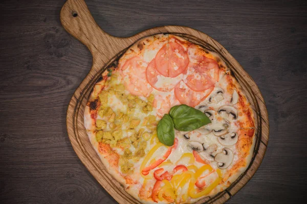 Sıcak parça rustik ahşap bir masa üzerinde erimiş peynirli pizza