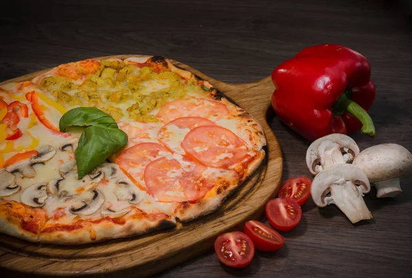 Sıcak parça rustik ahşap bir masa üzerinde erimiş peynirli pizza