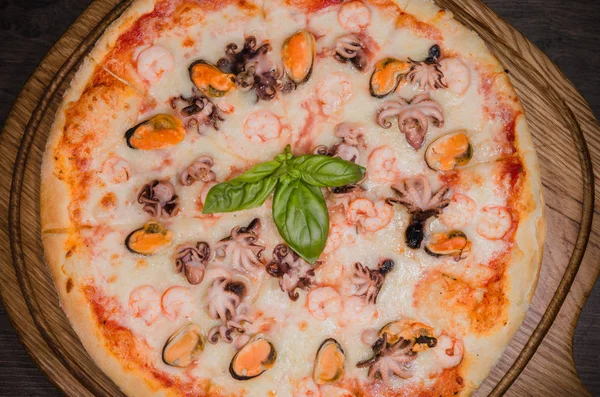 Sıcak parça rustik ahşap bir masa üzerinde erimiş peynirli pizza