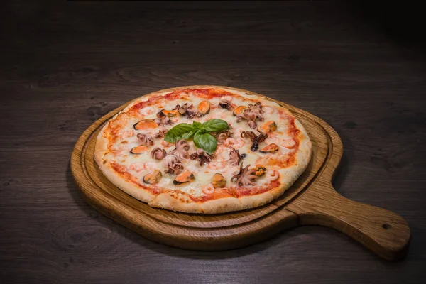 Sıcak parça rustik ahşap bir masa üzerinde erimiş peynirli pizza