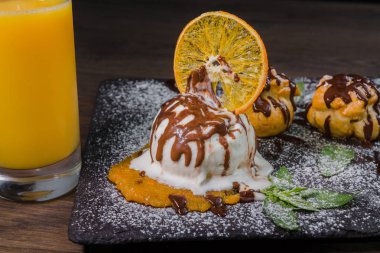 Bir top dondurma bir bardak portakal suyu bir taş zemin üzerine